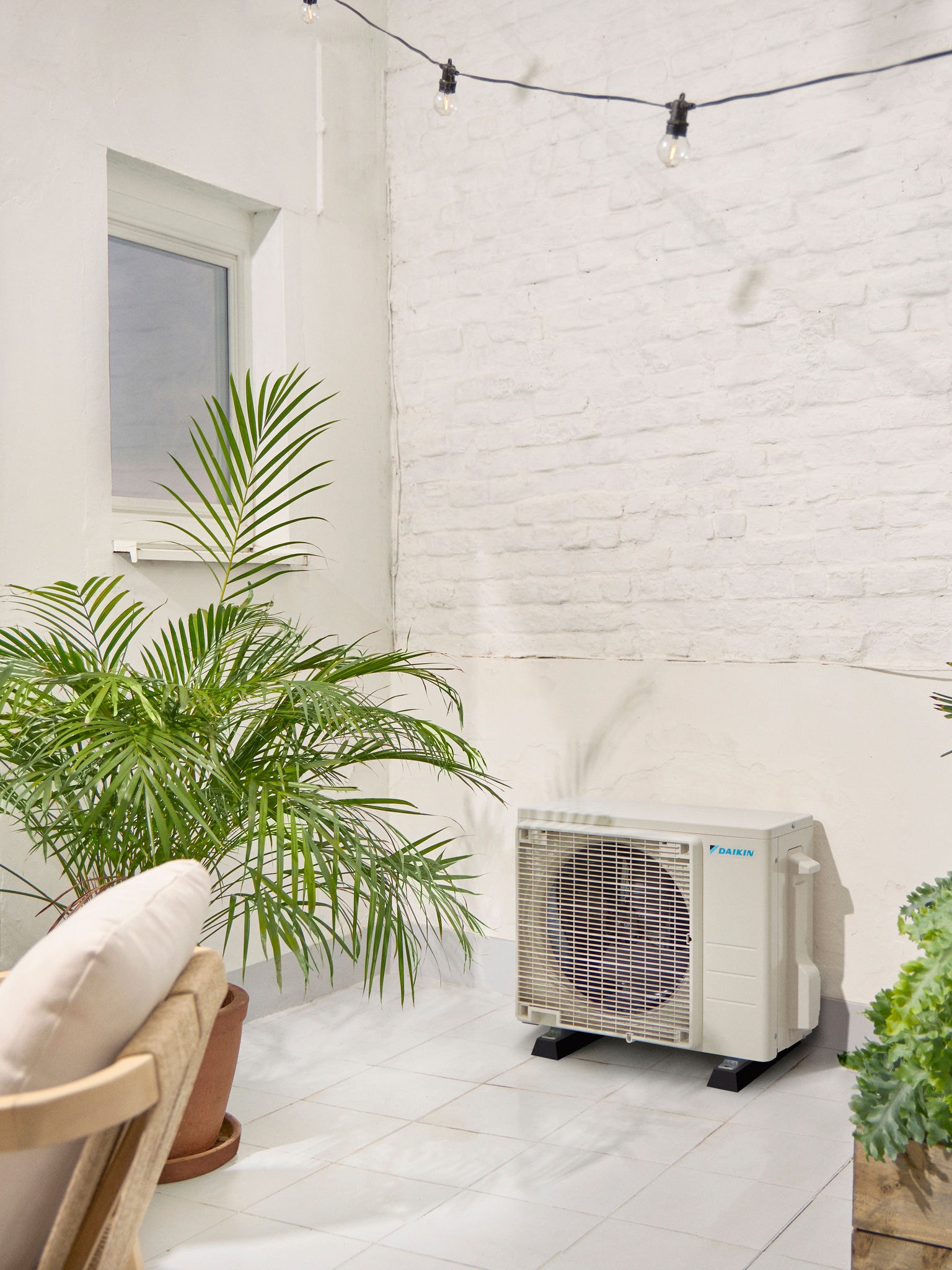 Daikin Außengerät auf einer Terrasse mit Pflanze