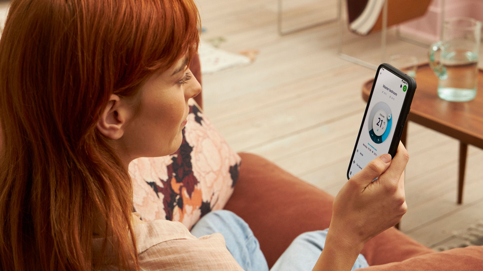 Eine Frau bedient ihr Heizsystem via App