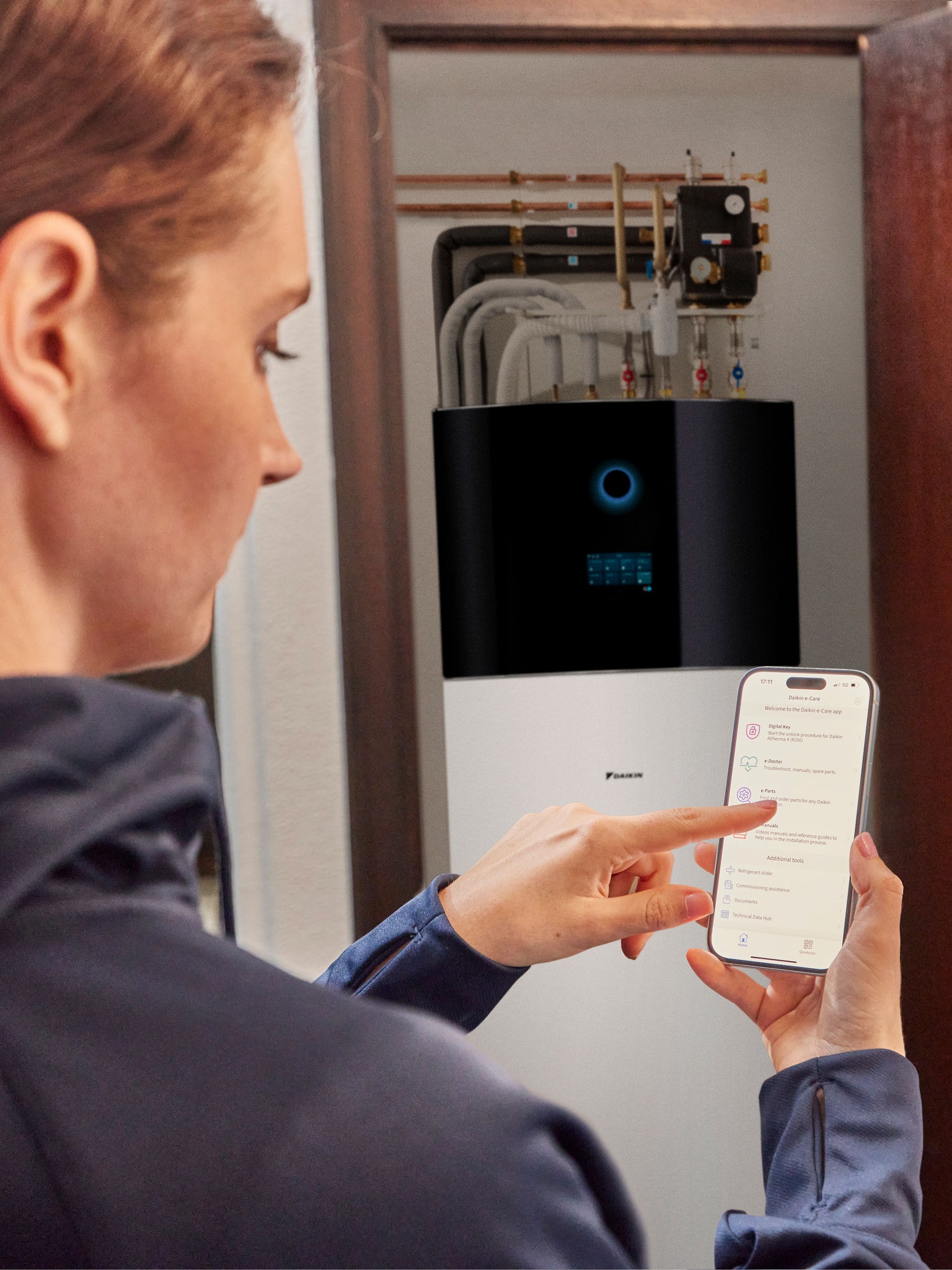 Eine Frau bedient über Smartphone eine Wärmepumpe in einem modernen Zuhause