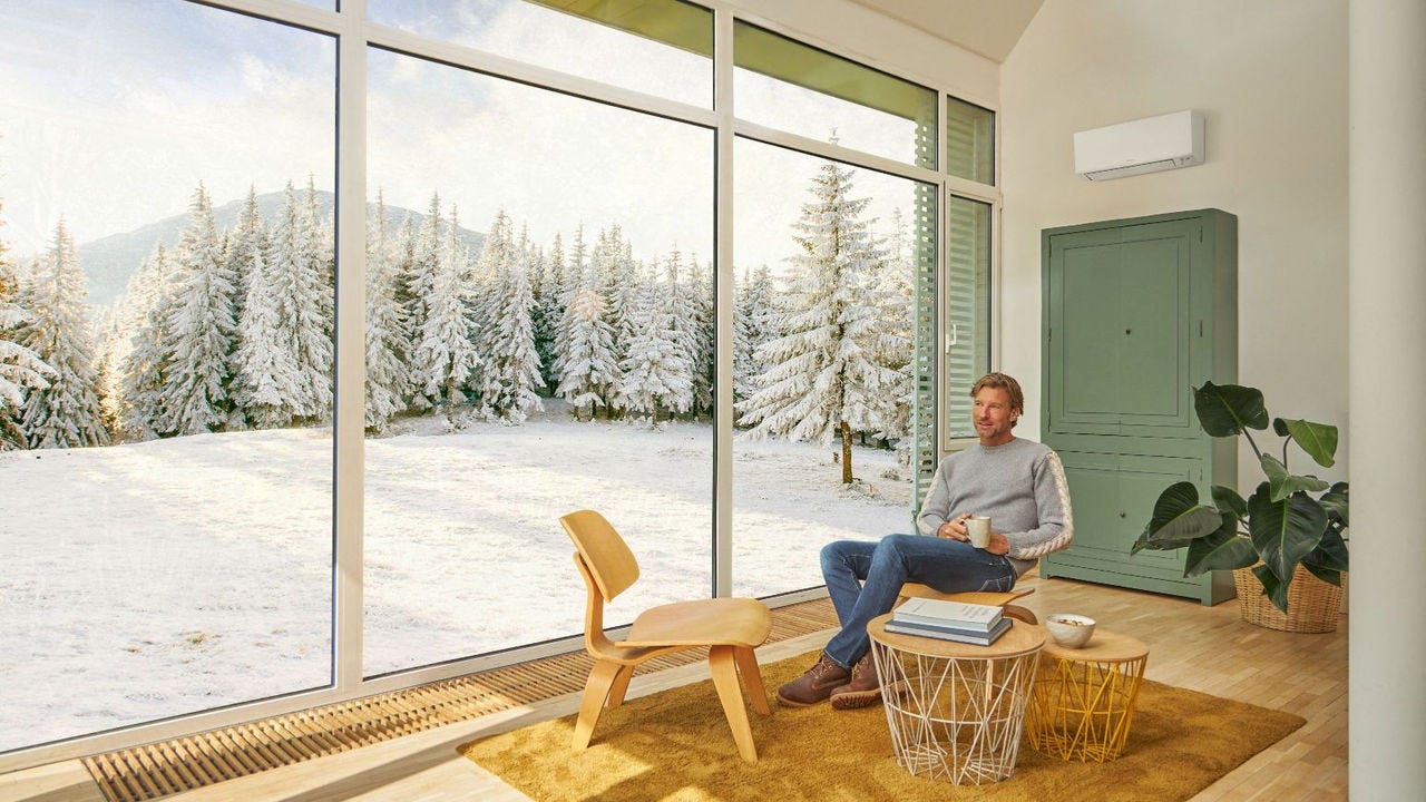 Ein Mann sitzt auf der Couch und genießt die Wärme der Klimaanlage