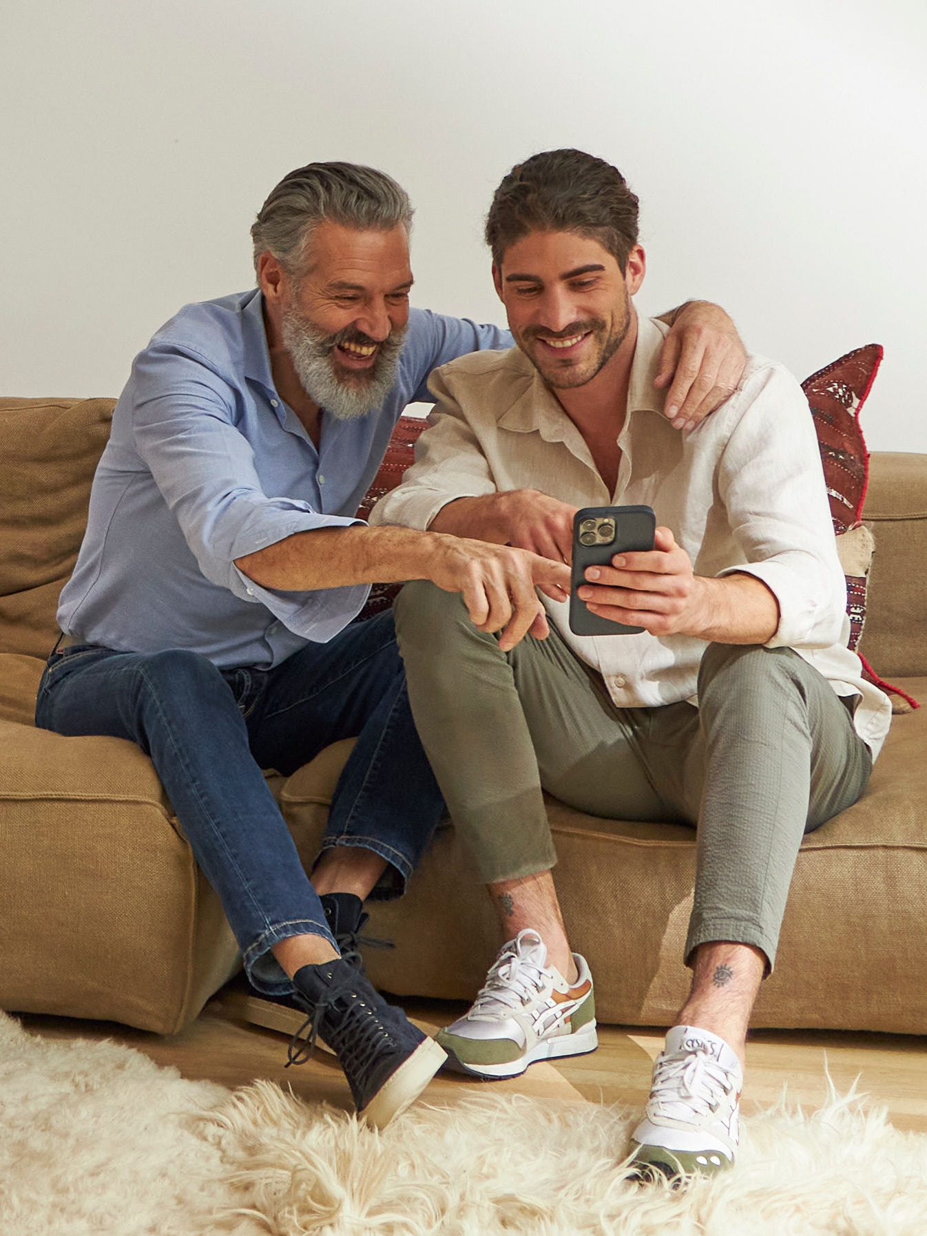 Der Vater und sein erwachsener Sohn sitzen auf der Couch und genießen die ideale Raumtemperatur