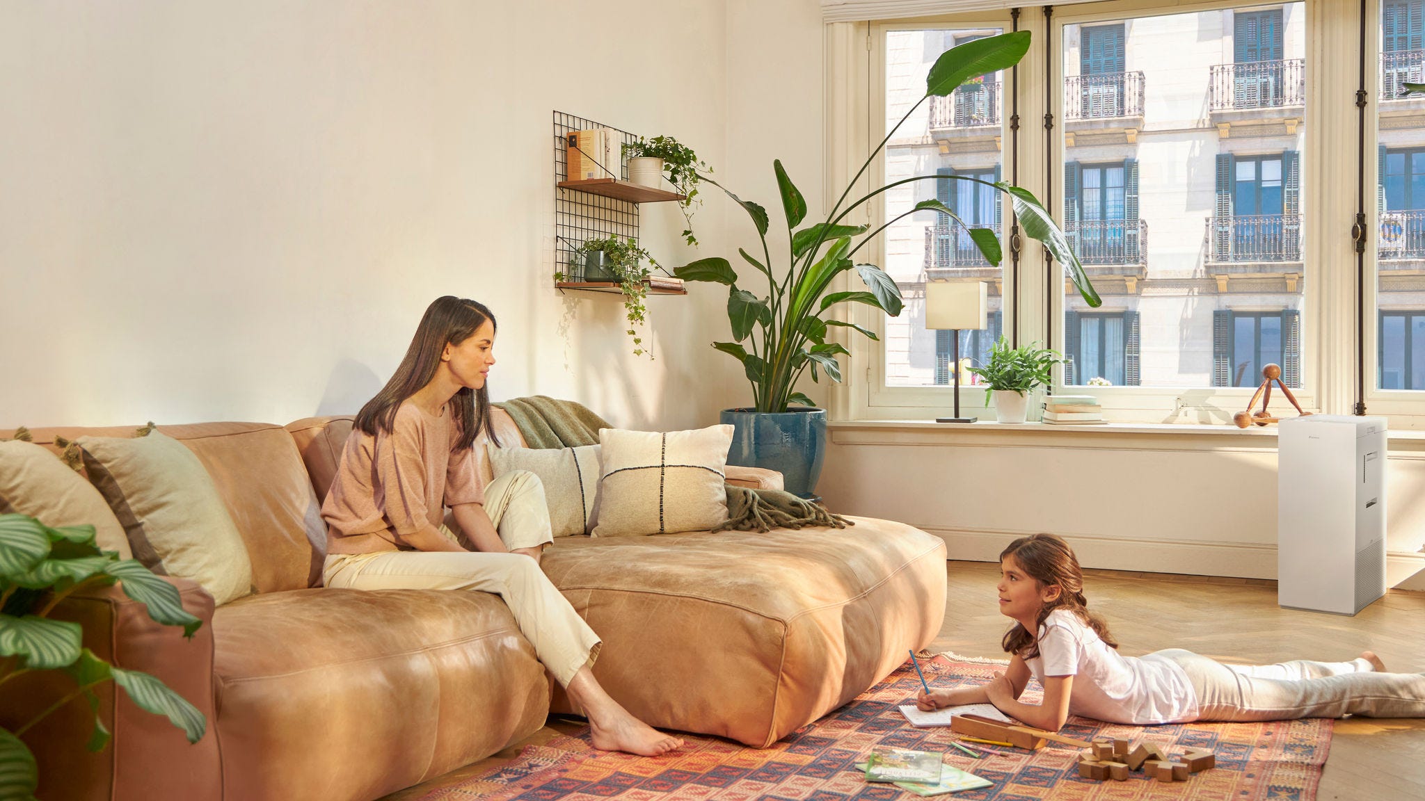 Mutter und Kind zu Hause mit einem Luftreiniger, der Allergene in Innenräumen reduziert und die Luftqualität verbessert