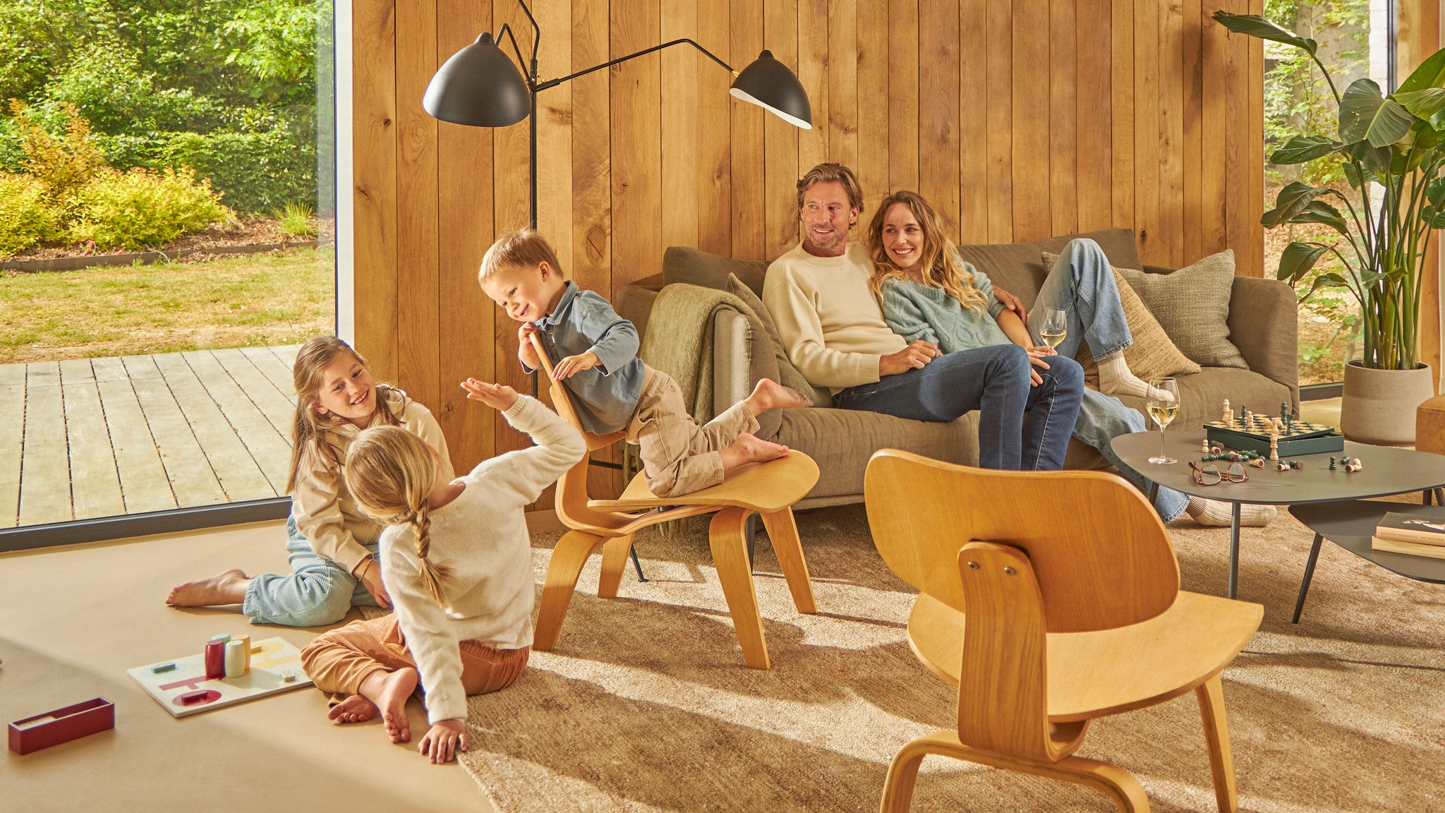 Lachende vierköpfige Familie bei einem Brettspiel in ihrer gut belüfteten Küche
