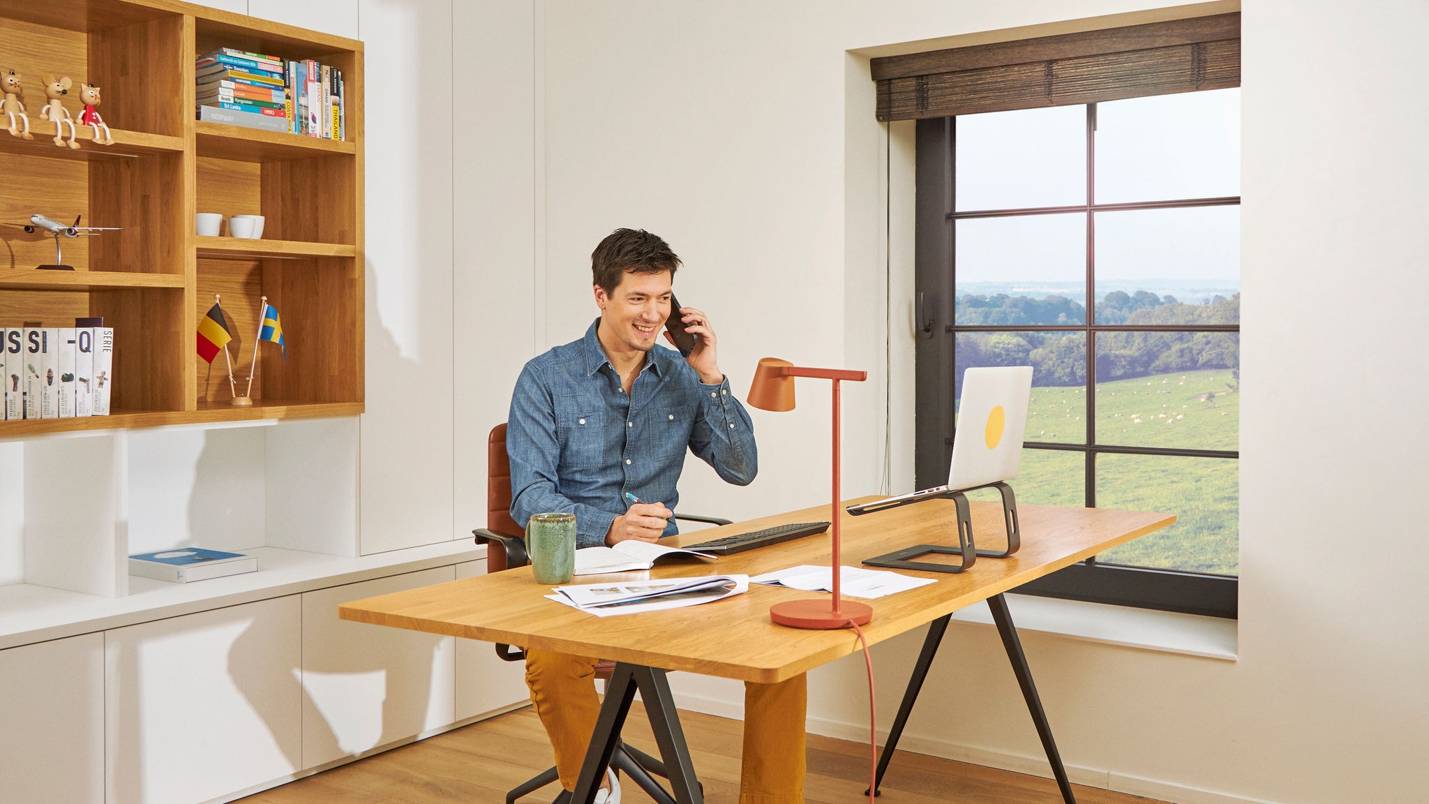 Mann telefoniert am Schreibtisch im Homeoffice bei bester Raumluftqualität