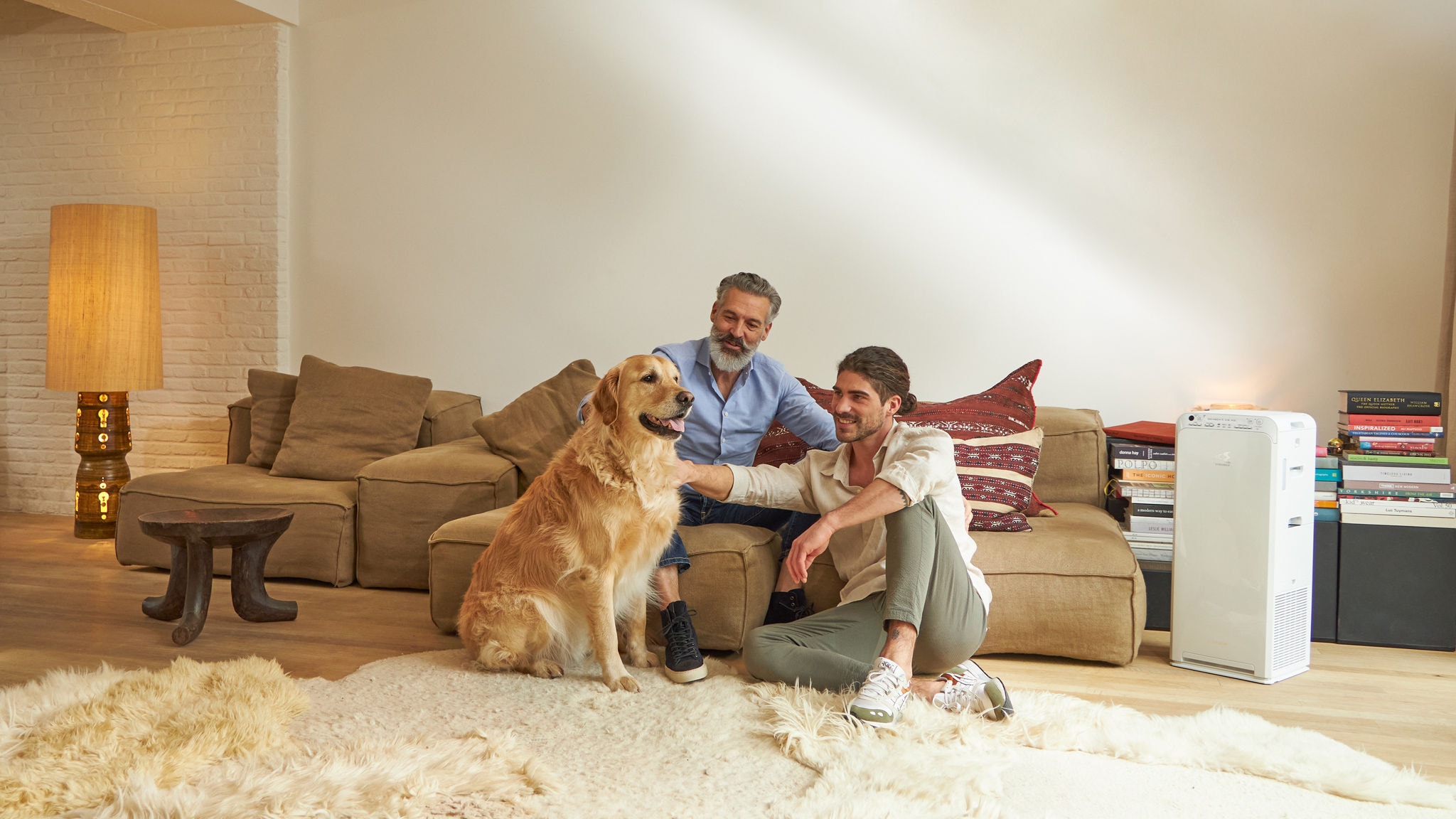 Vater und Sohn streicheln ihren Hund und haben dank des Daikin Luftreinigers keine Sorgen wegen der Hundehaare
