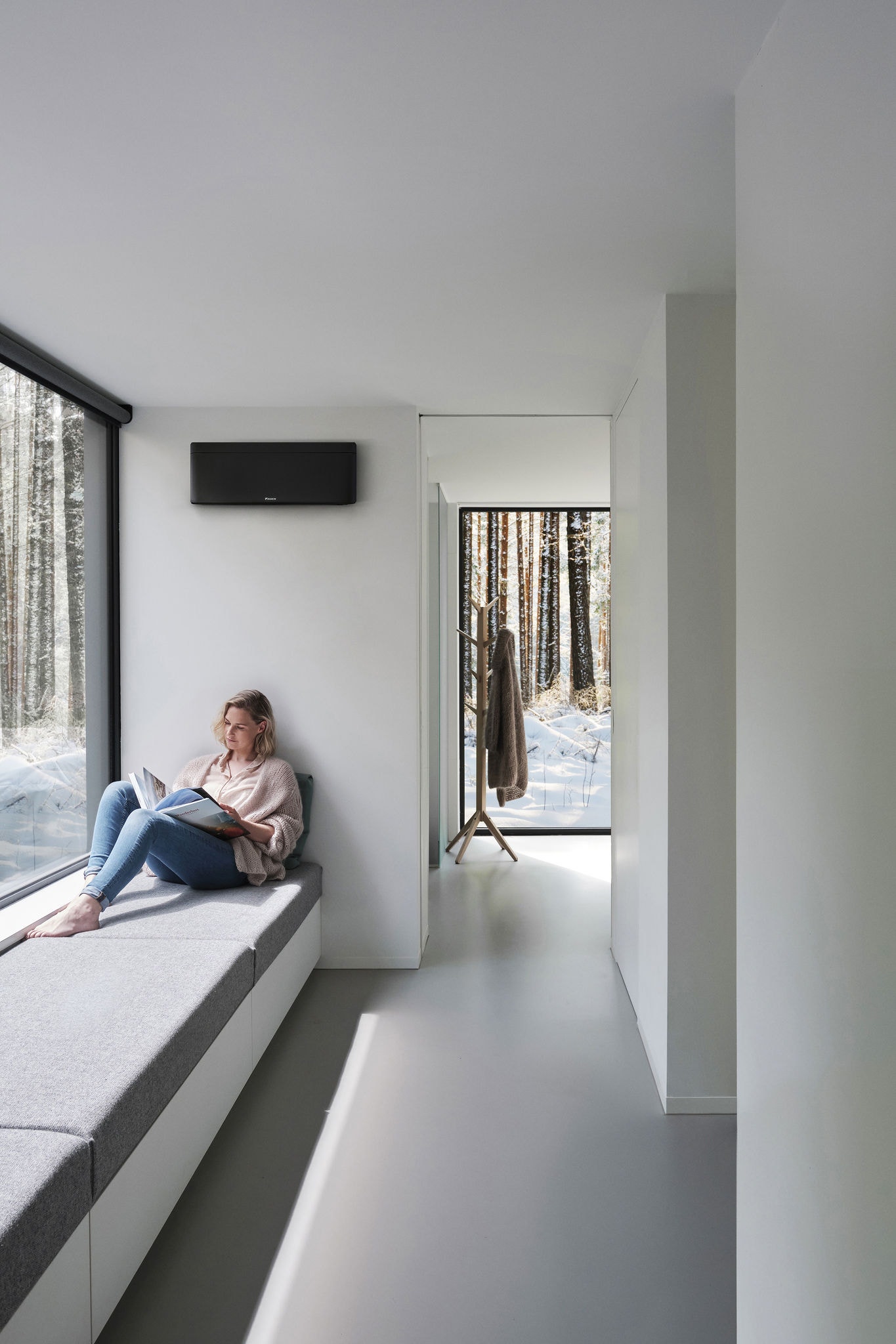 Eine Frau liegt auf einer Fensterbank und liest in einem Buch