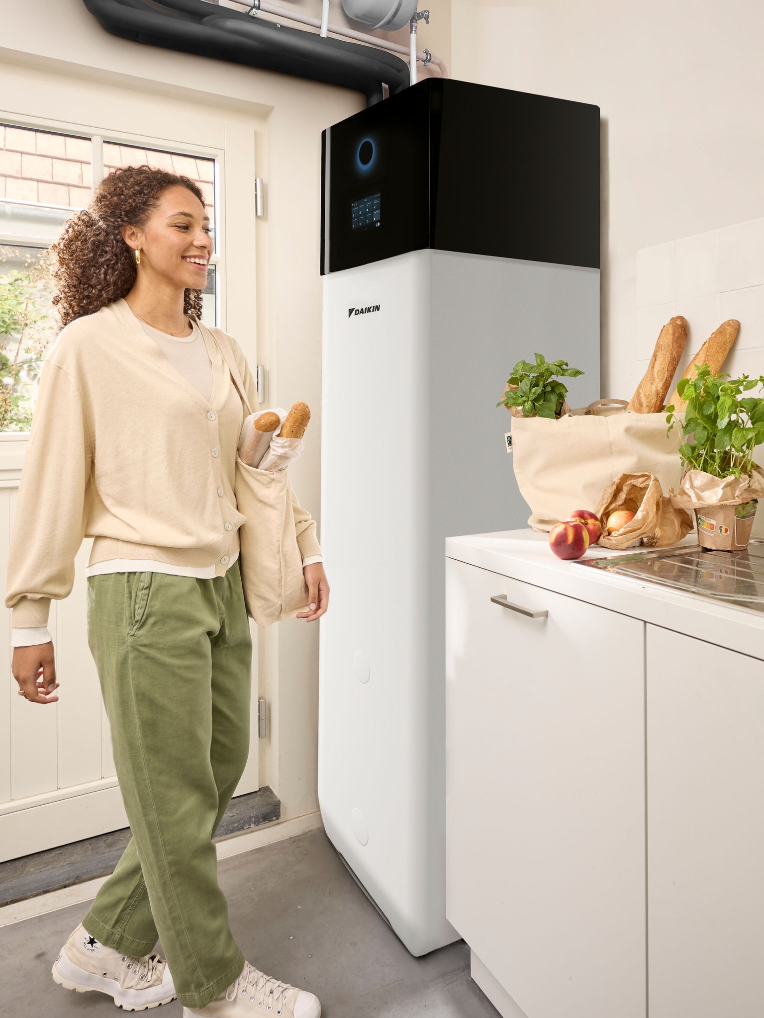 Eine vom Einkauf nach Hause kommende Frau trägt Tüten mit Lebensmitteln