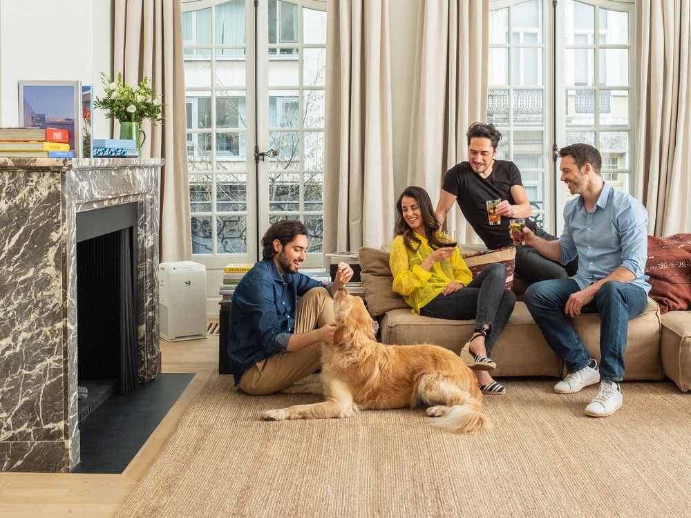 Familie mit Hund im Wohnzimmer am Boden sitzend