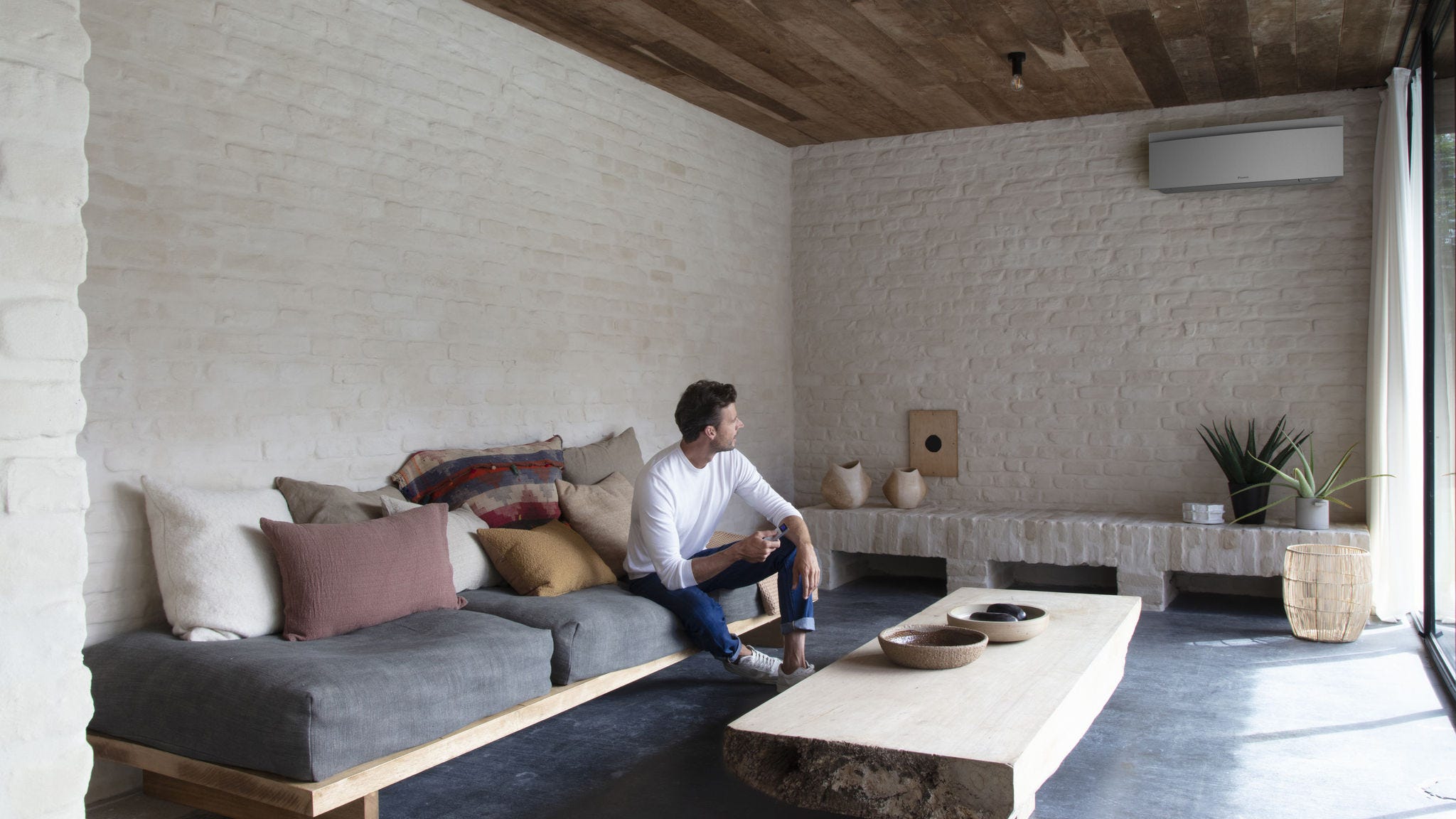 Ein Mann bringt ein Stylish Innengerät an einer Wand an.