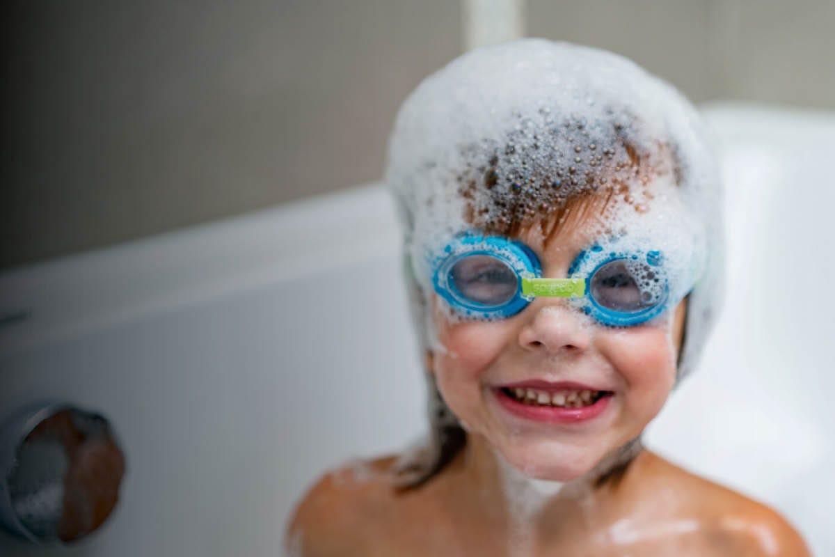 Kind in der Badewanne mit Schwimmbrille