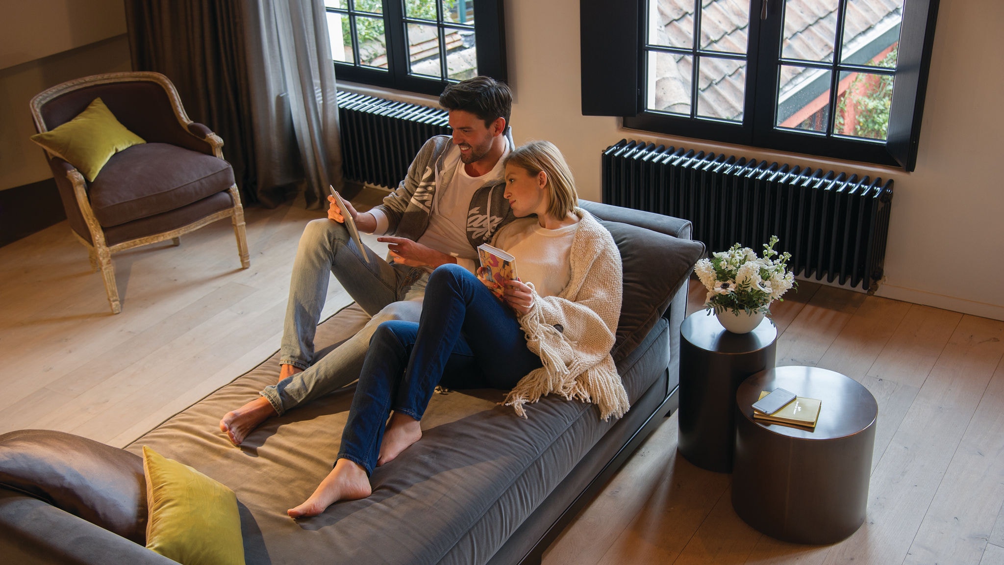 Ein Paar entspannt sich auf der Couch und schaut auf das Tablet