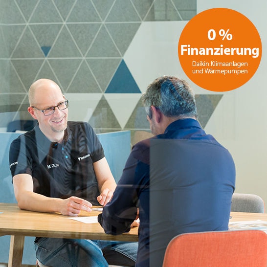 Zwei Männer sitzen an einem Tisch und unterhalten sich