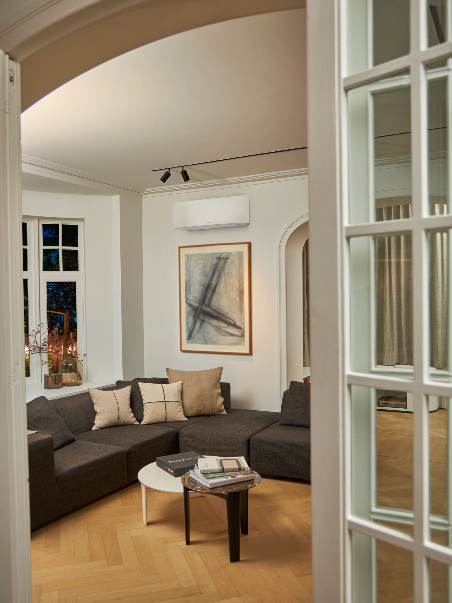 Wohnzimmer mit Sofa und mit einem Klimagerät an der Wand