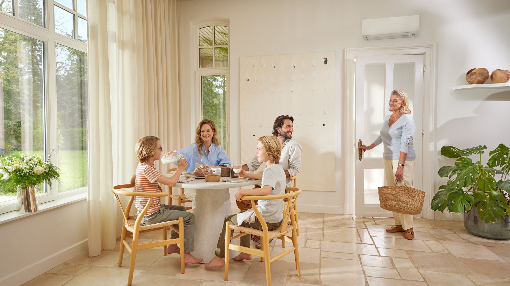 Eine Familie entspannt sich im Wohnzimmer und genießt den Komfort und die Kühle einer DAIKIN Komfortlösung