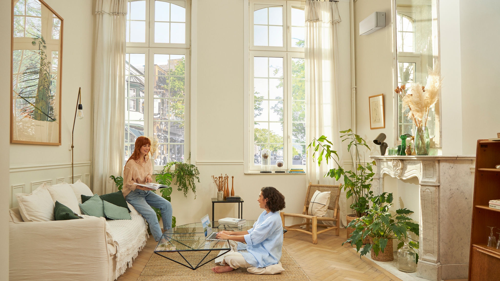 Eine Frau, die dank einer Daikin Luft-Luft-Wärmepumpe entspannt im Wohnzimmer sitzt