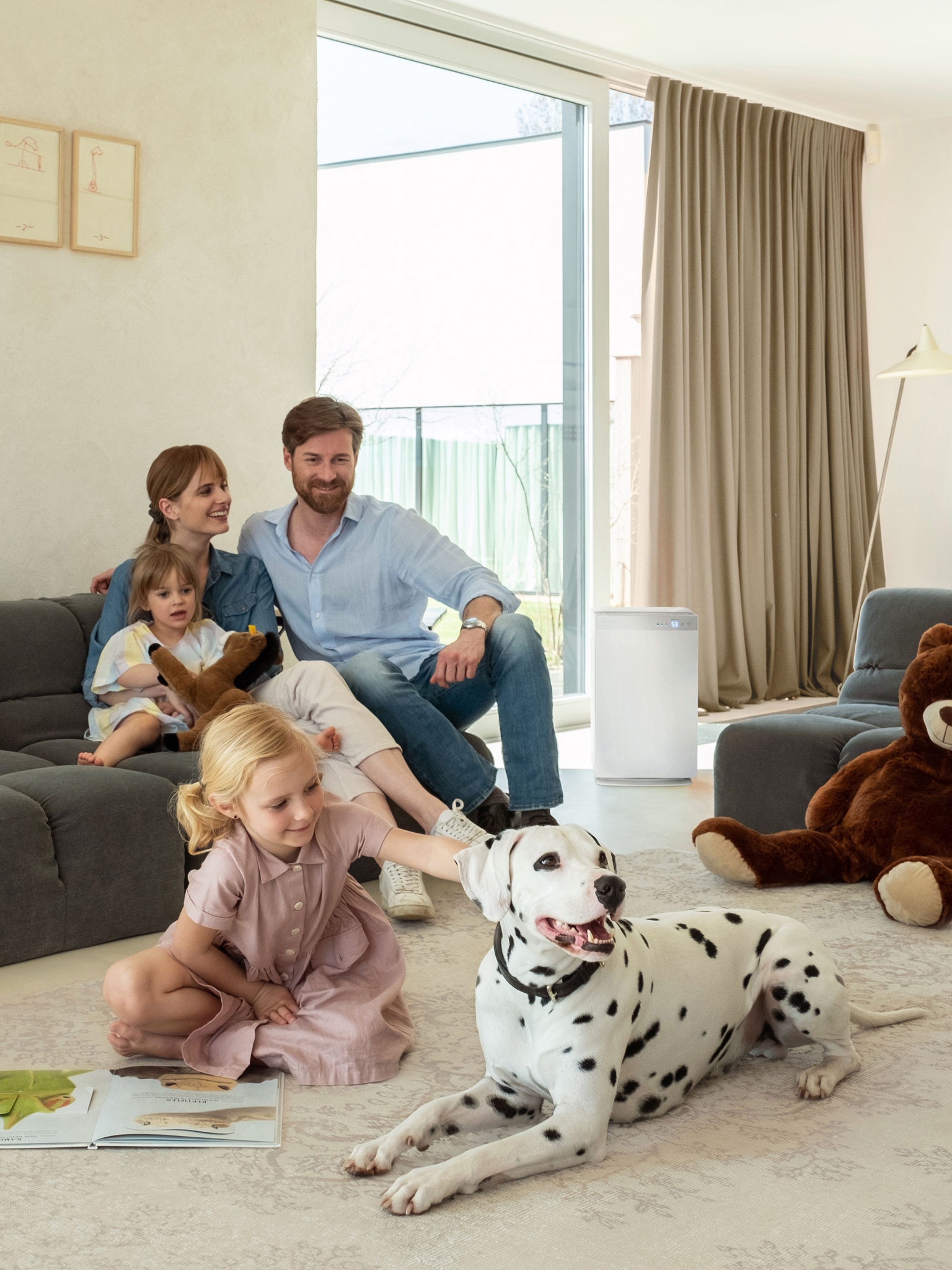 Eine Familie mit zwei Kindern und einem Dalmatiner entspannt sich im Wohnzimmer bei guter Luftqualität