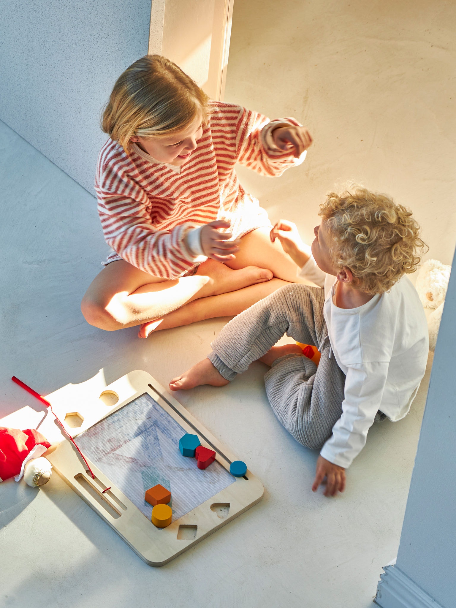 Zwei Kinder spielen und unterhalten sich, in einem perfekt geheizten Raum