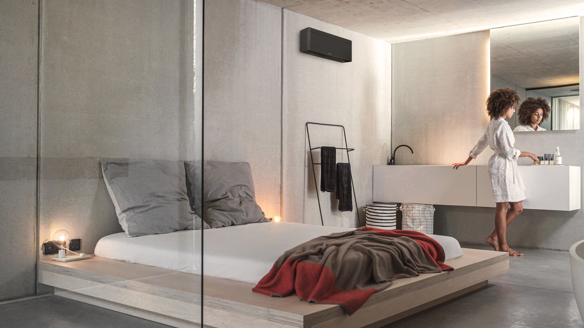 Eine Frau in ihrem Schlafzimmer mit einer stilvollen Daikin Klimaanlage