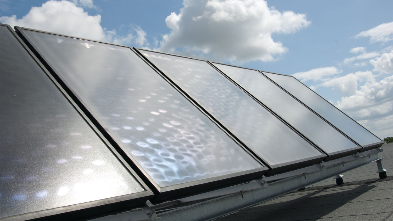 Auf dem Dach installierte Solarkollektoren, angeschlossen an eine Daikin Wärmepumpe, um Synergien zu schaffen und Geld zu sparen